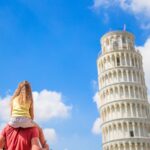 Family of dad and kid background the Learning Tower in Pisa. Pisa – travel to famous places in Europe.